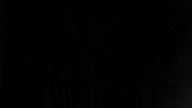 a person is standing in a dark room holding a sword .