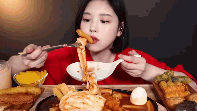 a woman is eating food with a fork and spoon .