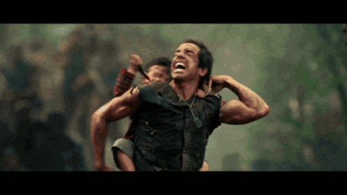 a man is carrying another man on his shoulders and they are laughing