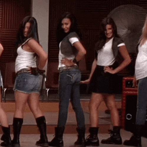 a group of women standing next to each other with one wearing shorts