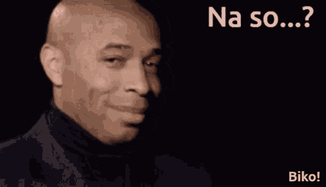 a man in a black turtleneck is smiling with the words na so ... ? behind him