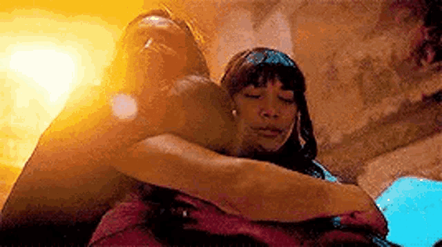 a man and a woman hugging each other in a room .