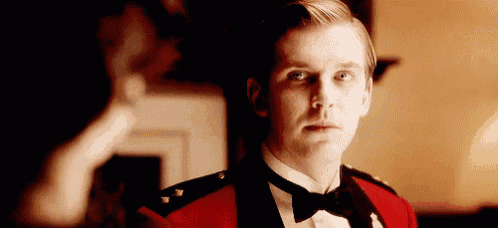 a man in a tuxedo and bow tie is standing in a room .
