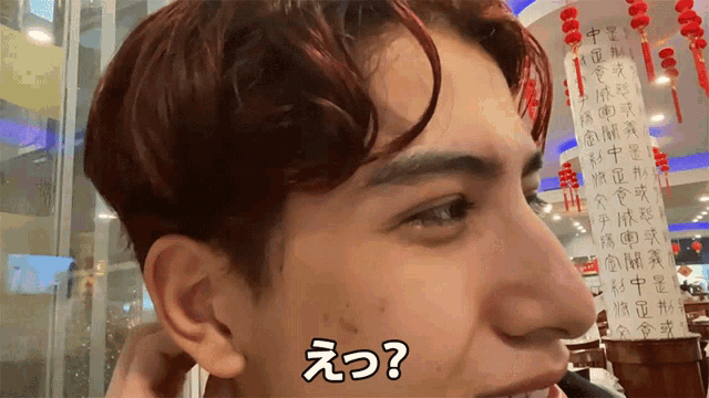 a man with chinese writing on his forehead has a question mark above his head