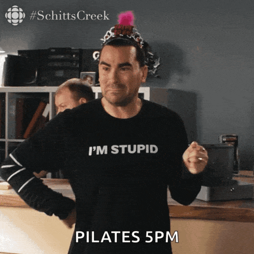a man wearing a shirt that says i 'm stupid pilates 5 pm