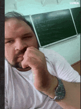 a man sitting in front of a blackboard with the number 1 on it