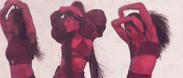 a group of women are dancing together and making a heart shape with their arms .