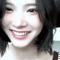 a close up of a woman 's face smiling with her teeth showing .
