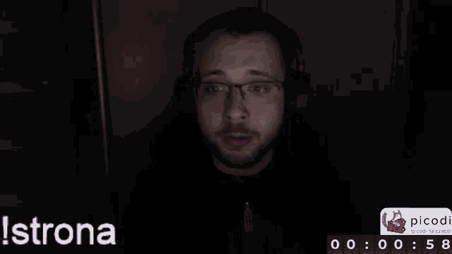 a man wearing glasses and headphones is sitting in front of a screen that says strona at the bottom