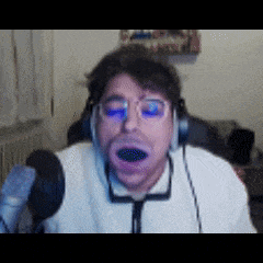 a man wearing headphones and glasses is making a funny face in front of a microphone