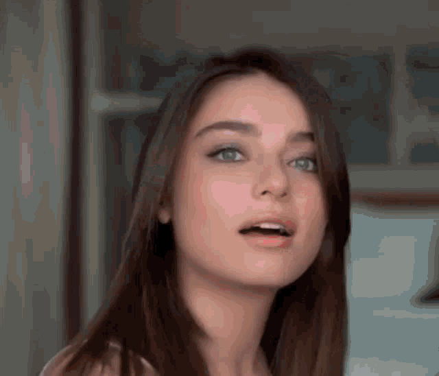 a close up of a woman 's face with her mouth open and a surprised look on her face .