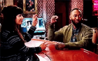 a man and a woman sitting at a bar talking
