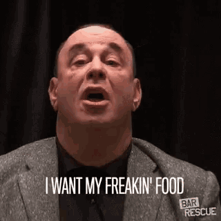 a man in a suit and tie is talking and saying `` i want my freakin ' food '' .