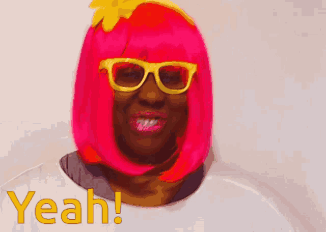 a woman wearing a pink wig and sunglasses says " yeah "