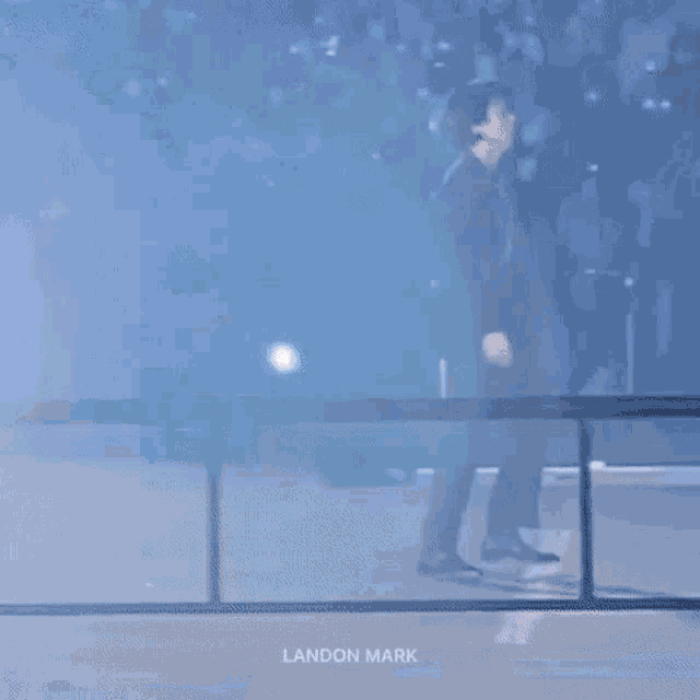 a person is standing in front of a blue light .