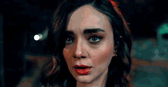 a close up of a woman 's face with red lips and green eyes