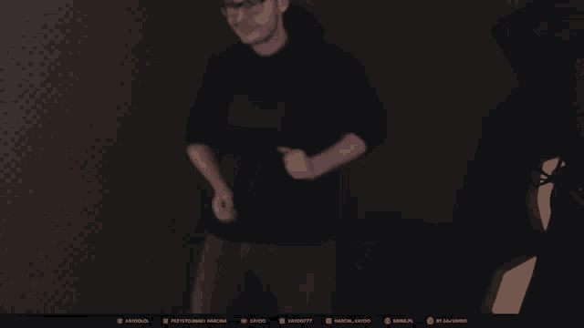 a screenshot of a twitch stream shows a man standing in the dark
