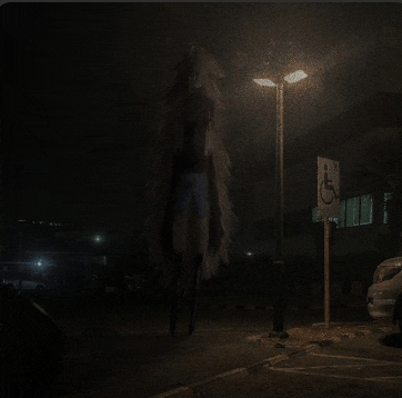 a dark parking lot with a handicapped parking sign
