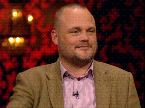 a man with a beard wearing a suit and a pink shirt