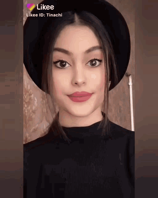 a girl wearing a black hat and a black sweater has likee written on her face