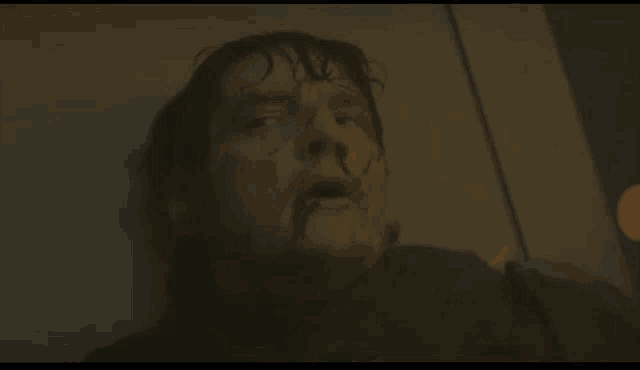 a close up of a man 's face in a dark room looking up .