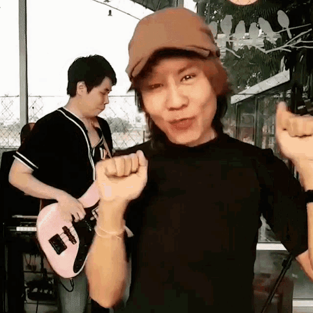 a man is playing a pink guitar and a woman is holding her fist up