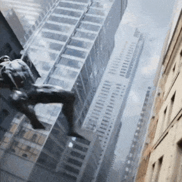 a statue of a man is hanging from the side of a building