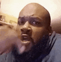 a bald man with a beard is making a funny face .
