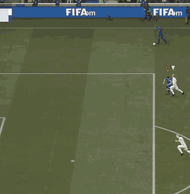 a soccer game is being played on a field with a blue banner that says fifa