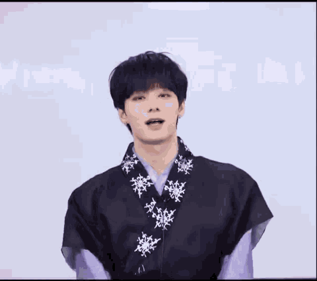 a young man wearing a purple shirt and a black shirt is dancing .