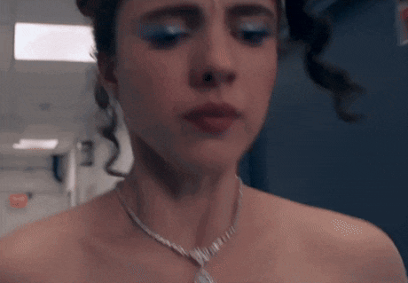 a close up of a woman wearing a necklace and blue eye shadow