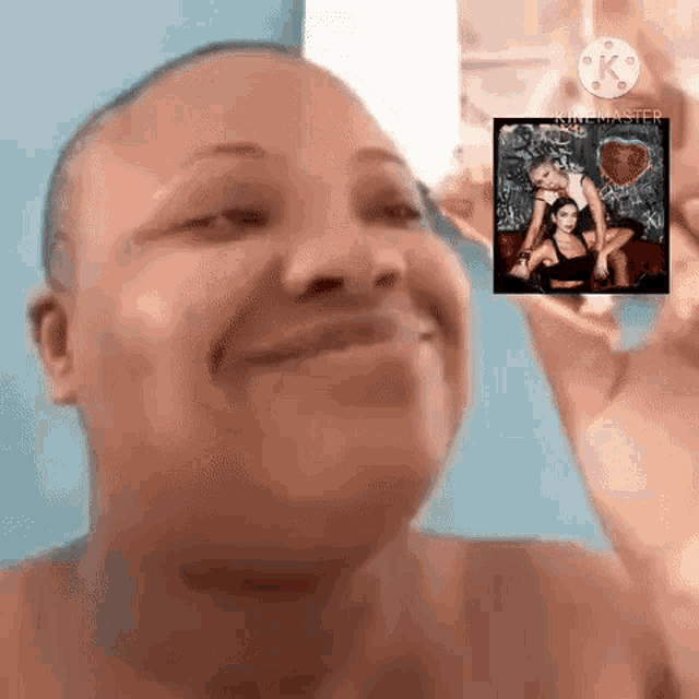 a woman is smiling while holding a picture of two women in front of her face .
