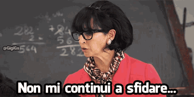 a woman wearing glasses stands in front of a blackboard with the words non mi continui a sfidare