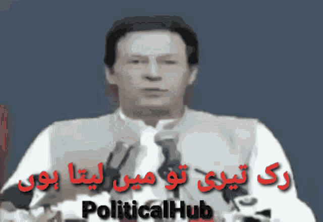 a man is giving a speech in front of microphones and the words politicalhub are visible in red