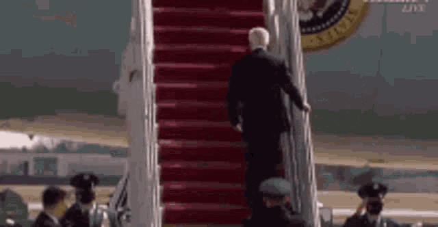 a man in a suit is walking up a set of stairs .
