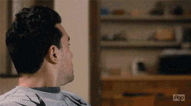 a man is sitting in front of a dresser with the word pop on the bottom