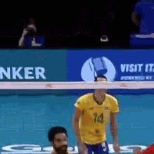 a man in a yellow shirt with the number 14 on it