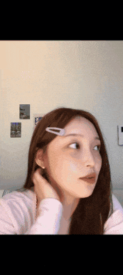 a woman with a hair clip in her hair is looking at the camera