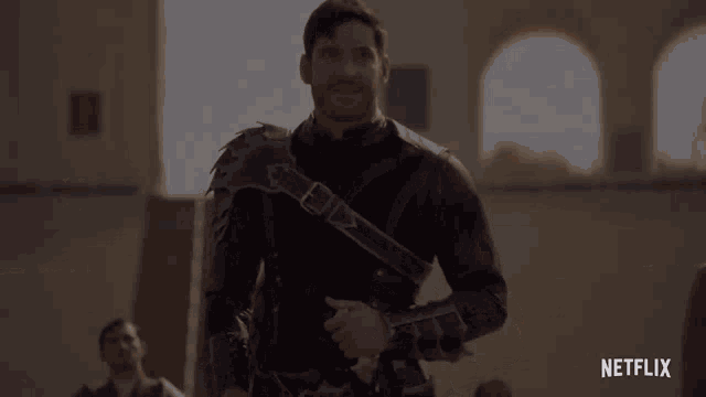 a man in a knight 's armor is standing in front of a building .