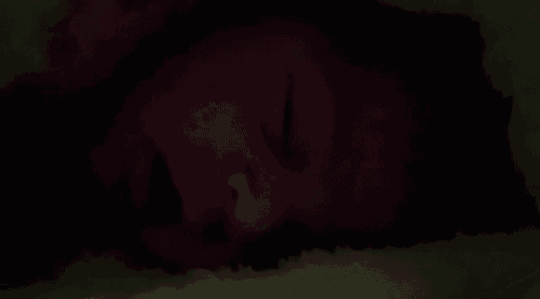 a close up of a person sleeping in a dark room