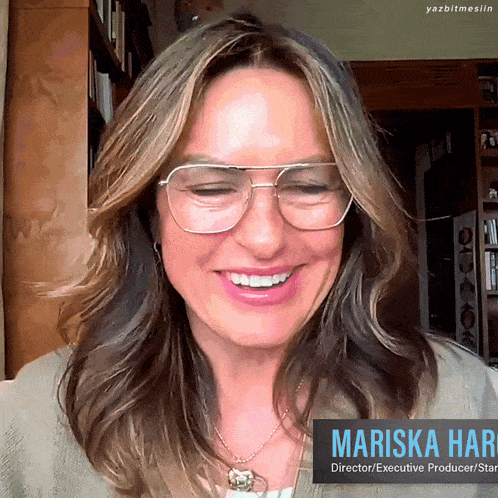 a woman wearing glasses and a necklace with the name mariska hart on it