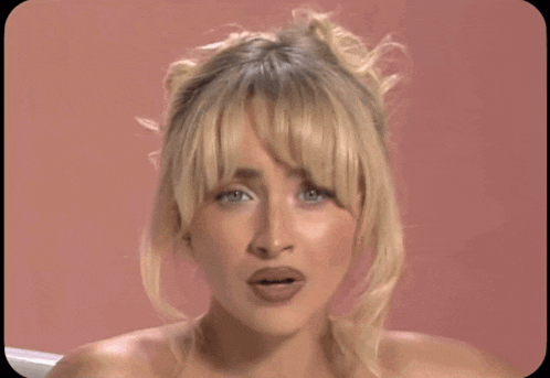 a woman with blonde hair and bangs is making a funny face