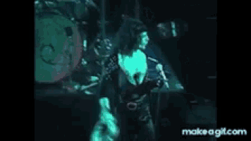 a woman singing into a microphone on a stage with a drum in the background .