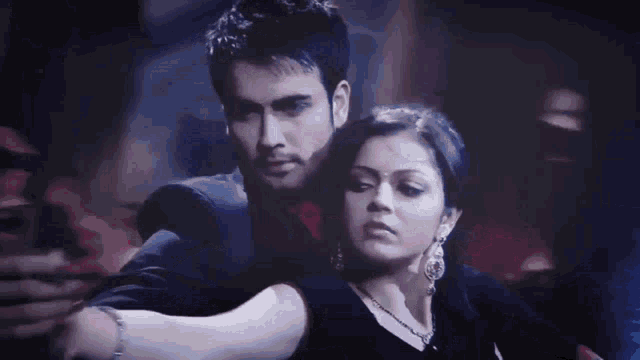 a man and a woman are dancing together and the woman is wearing earrings