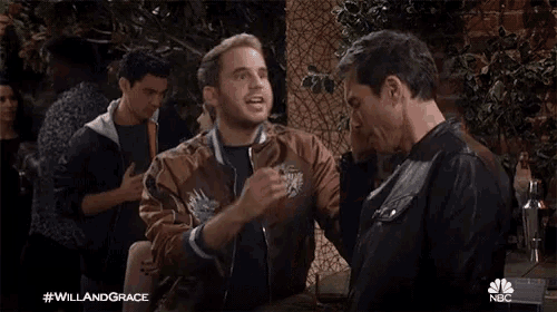 a man in a brown jacket is talking to another man