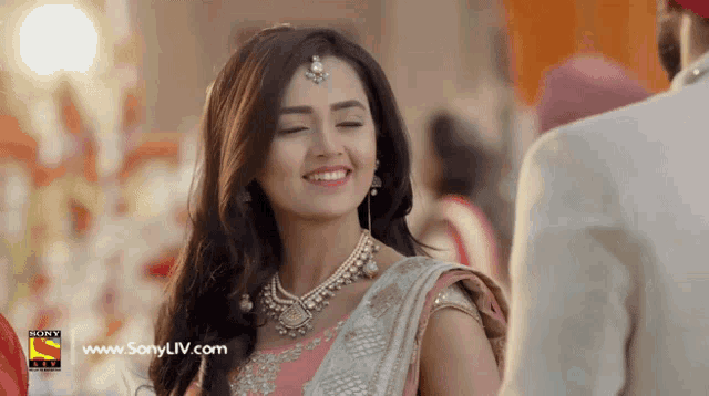 a woman is smiling in front of a sony logo