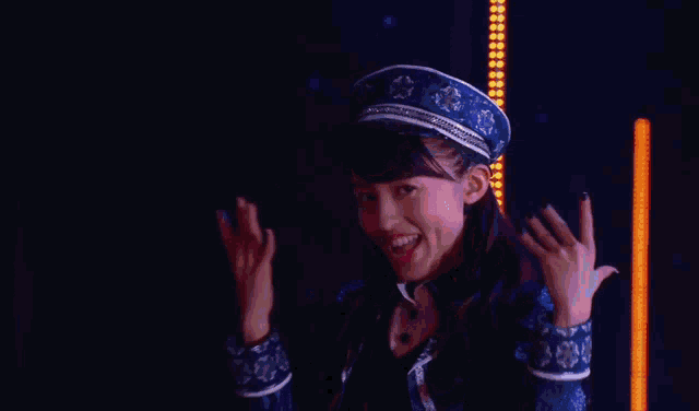 a woman wearing a blue hat and a blue jacket smiles