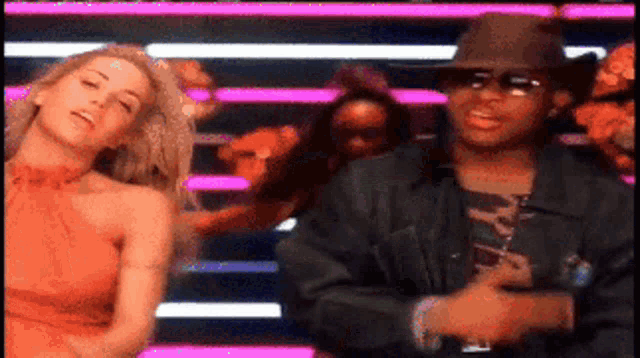 a man and a woman are dancing in front of a crowd