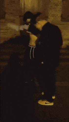 a person is doing a trick on the ground in front of a brick wall .