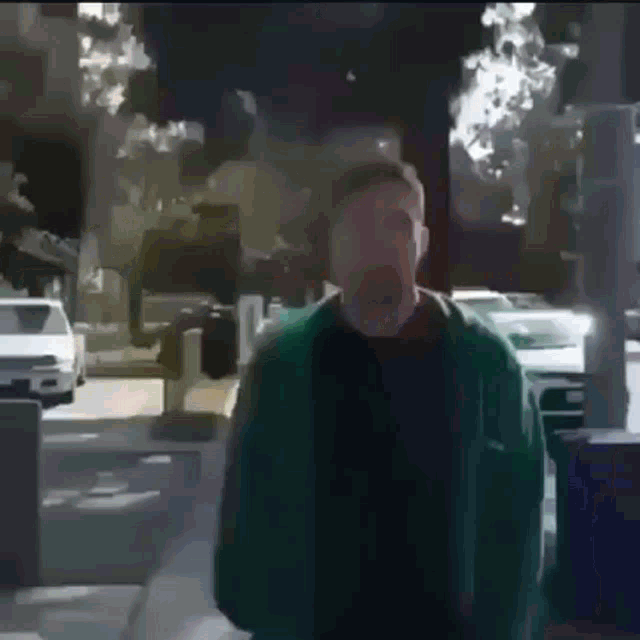 a man in a green jacket is standing on a street with his mouth wide open